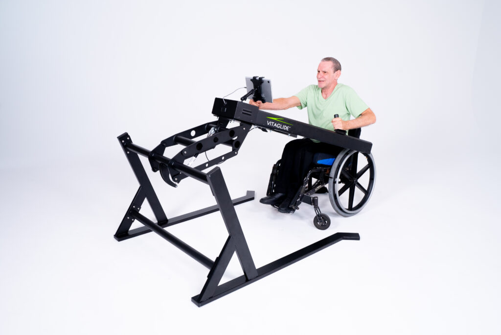 A man is using a Vitaglide exercise system that has a tablet function