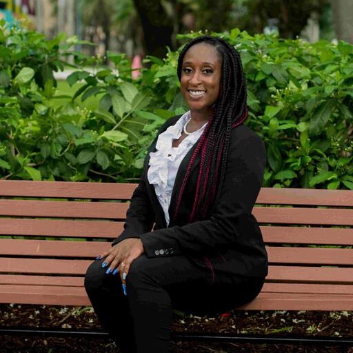 Photo of Attiya, sitting on a park bench
