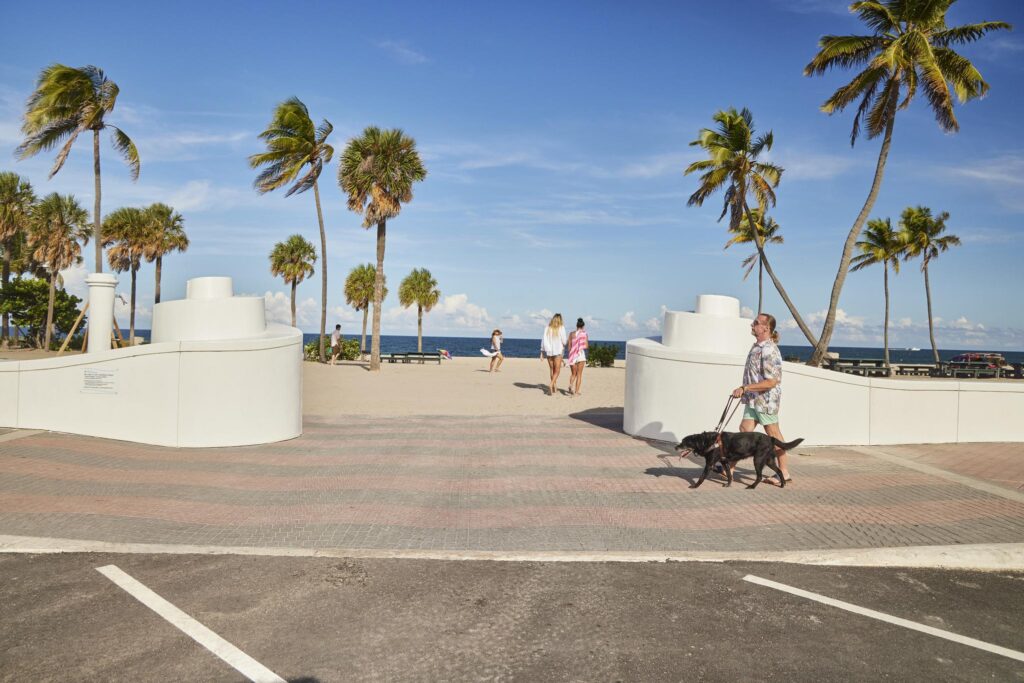 Man using a service dog enjoys a stroll on the accessible beaches in Ft. Lauderdale