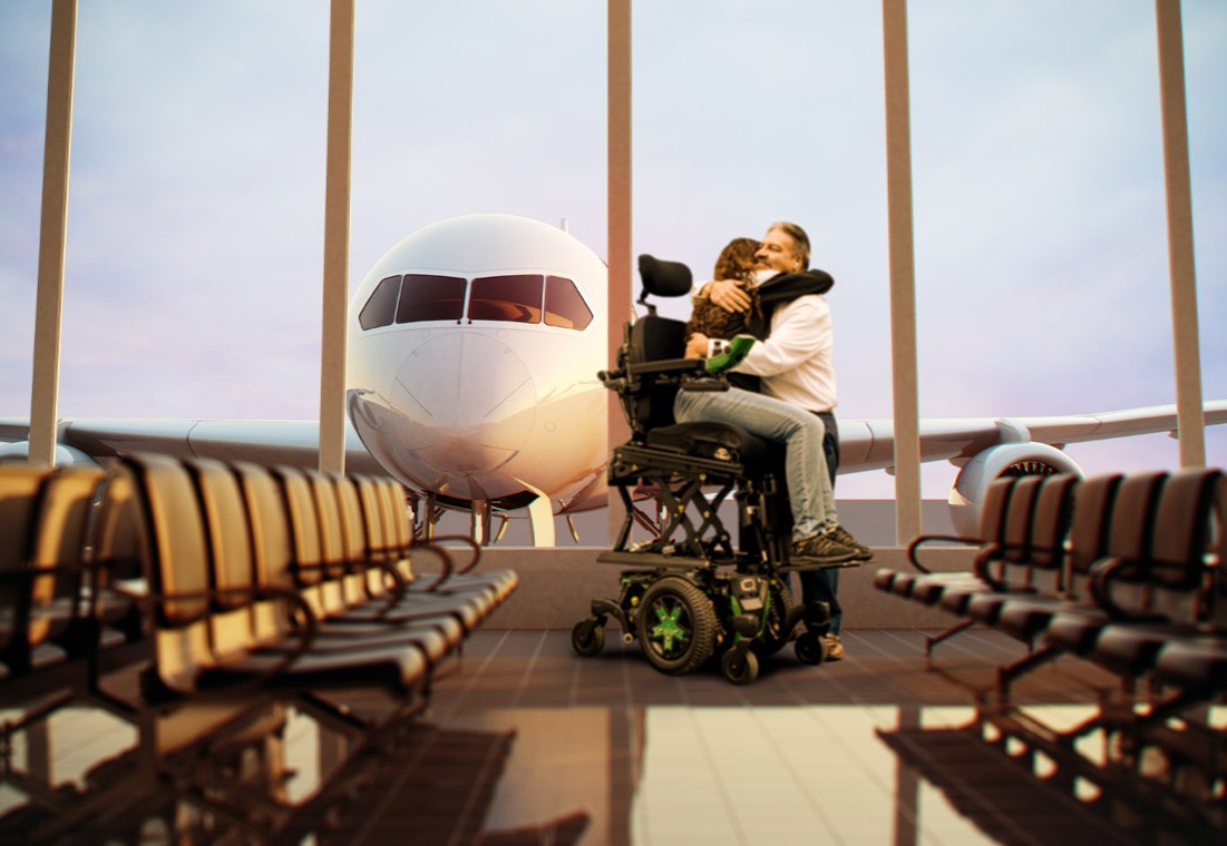 A person in an elevated wheelchair embraces their companion in the airport gate with a huge passenger plane visible just outside the floor to ceiling windows.