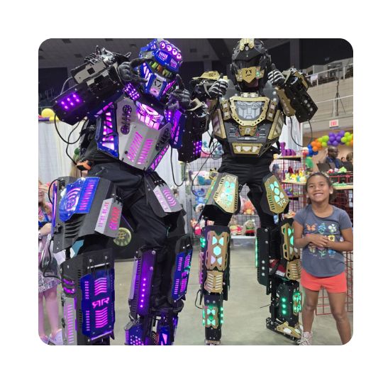 Two giant purple and silver Robot Stilt Walkers tower of a little kid as they pose for a picture.