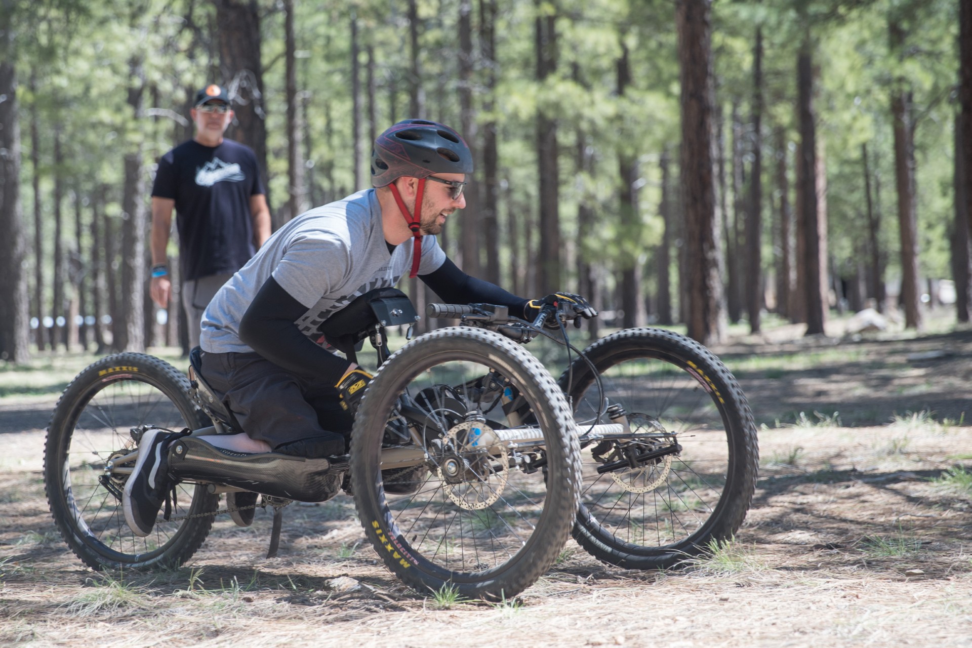 A man rides a high country adaptable bike through the woods