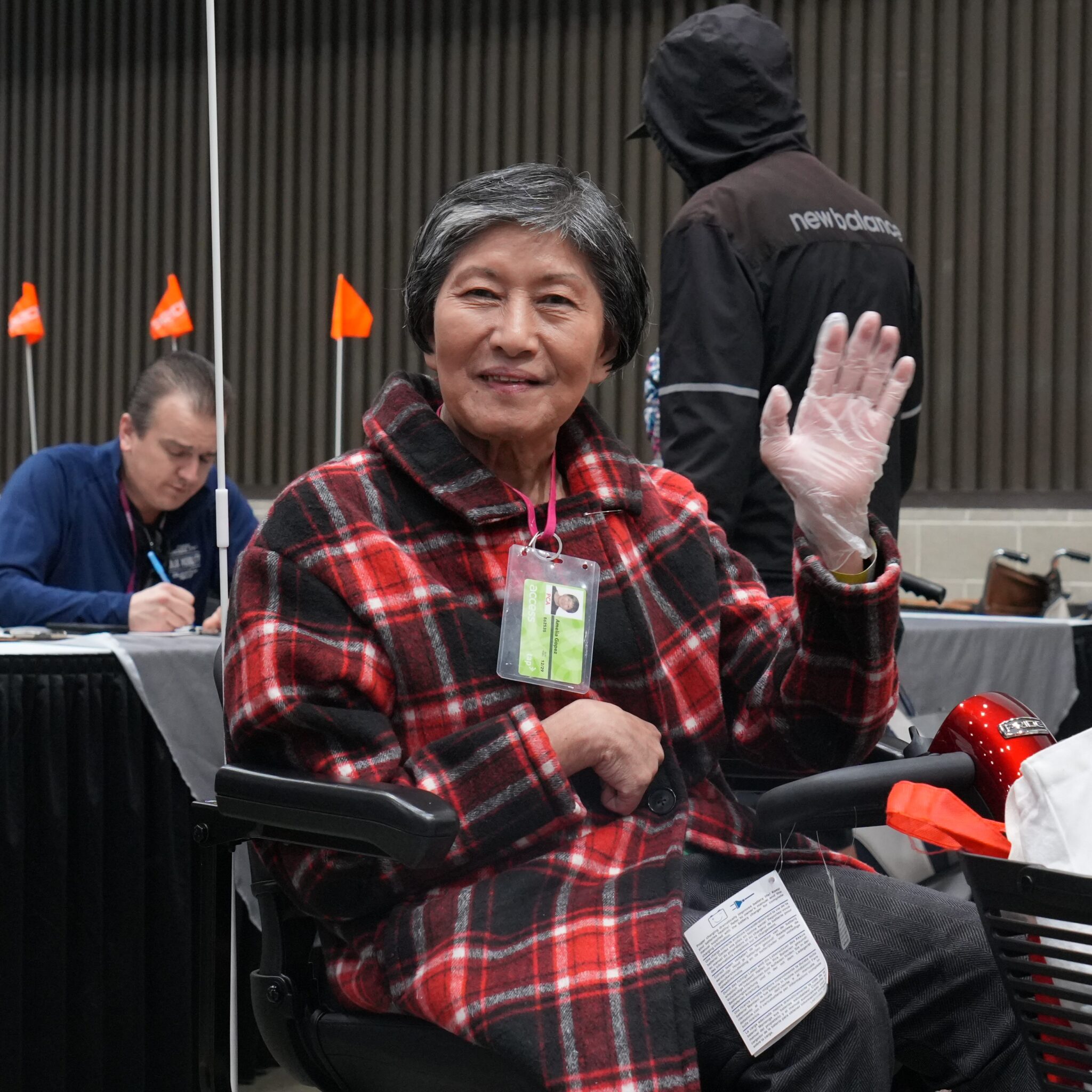 An elderly woman is using a pride mobility loaner scooter at abilities expo