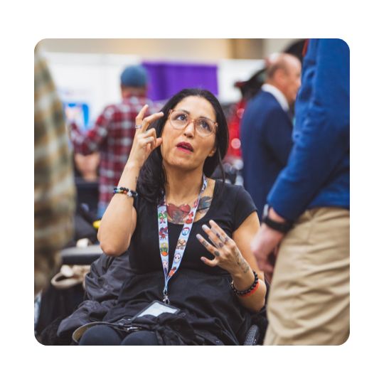 A woman is communicating in sign language at Abilities Expo.