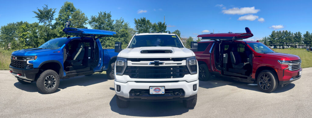 3 accessible trucks (in colors blue, white and red) are lined up next to each other