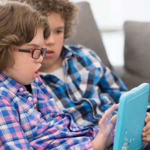 Two boys play on an tablet