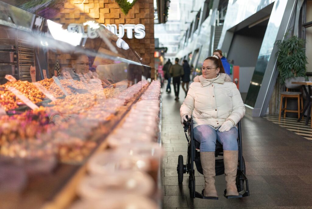 Woman in wheelchair looks at goods at a pop up market