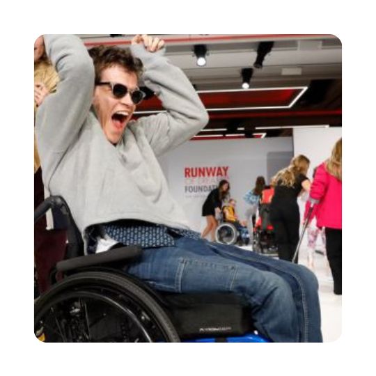 Several people decorate a runway, with a cheering man in the forefront