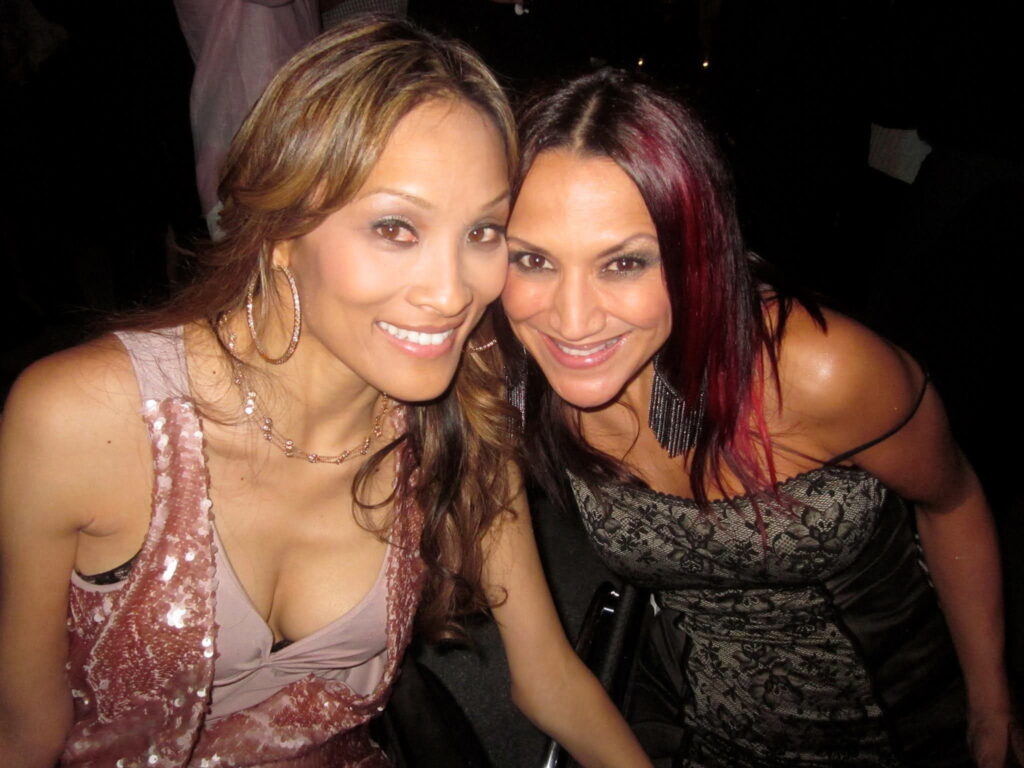 Photo of Angela and Auti, both wearing nice outfits and smiling at the camera