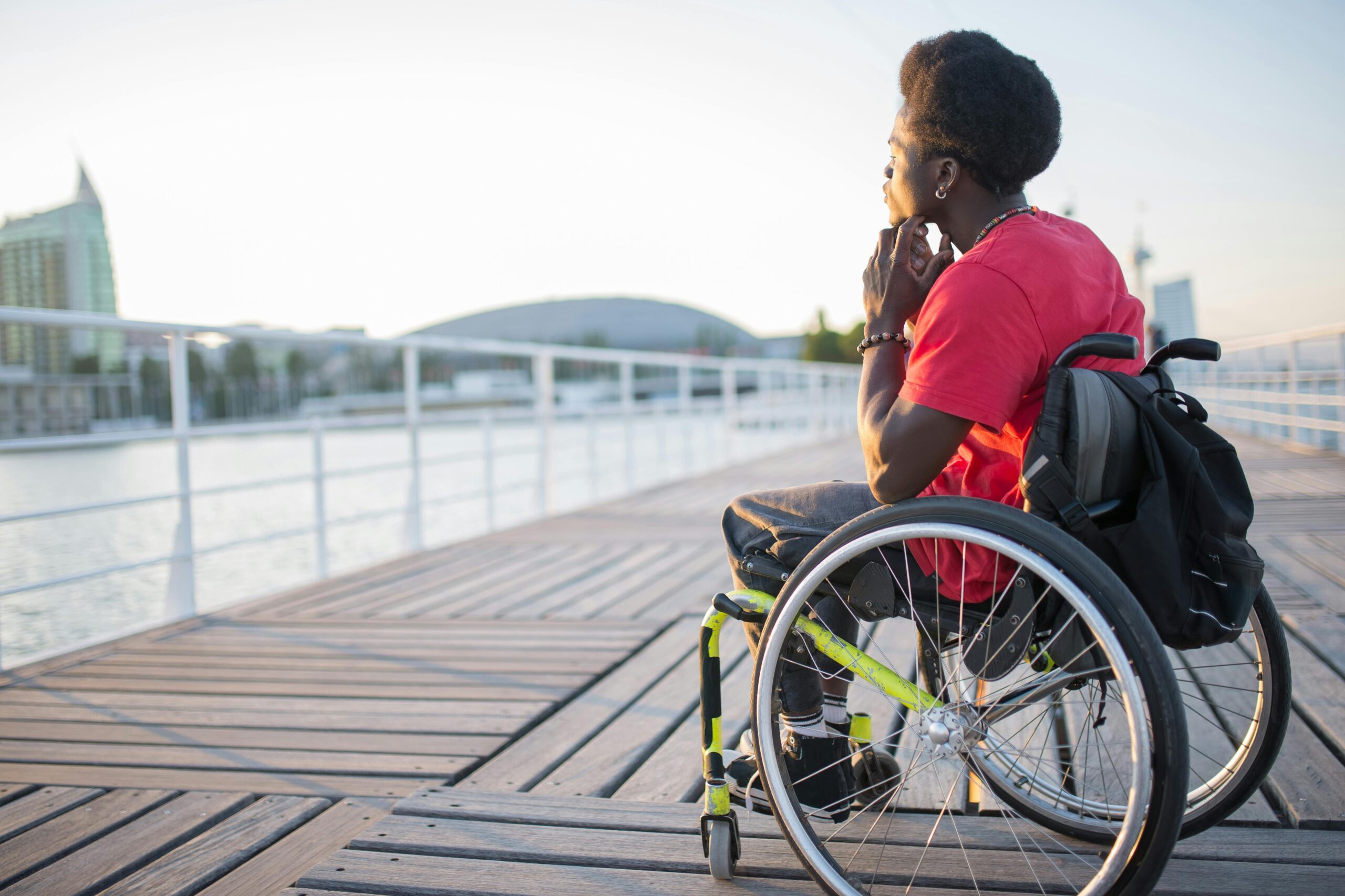 Man in wheelchair looks wistfully out to sea