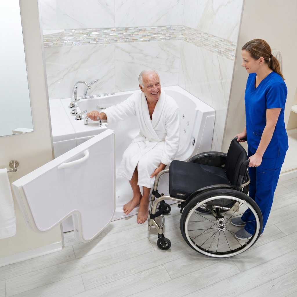 Caregiver assisting an older man using an Ella’s Bubbles wheelchair-accessible walk-in tub with wide transfer door and built-in therapeutic jets.