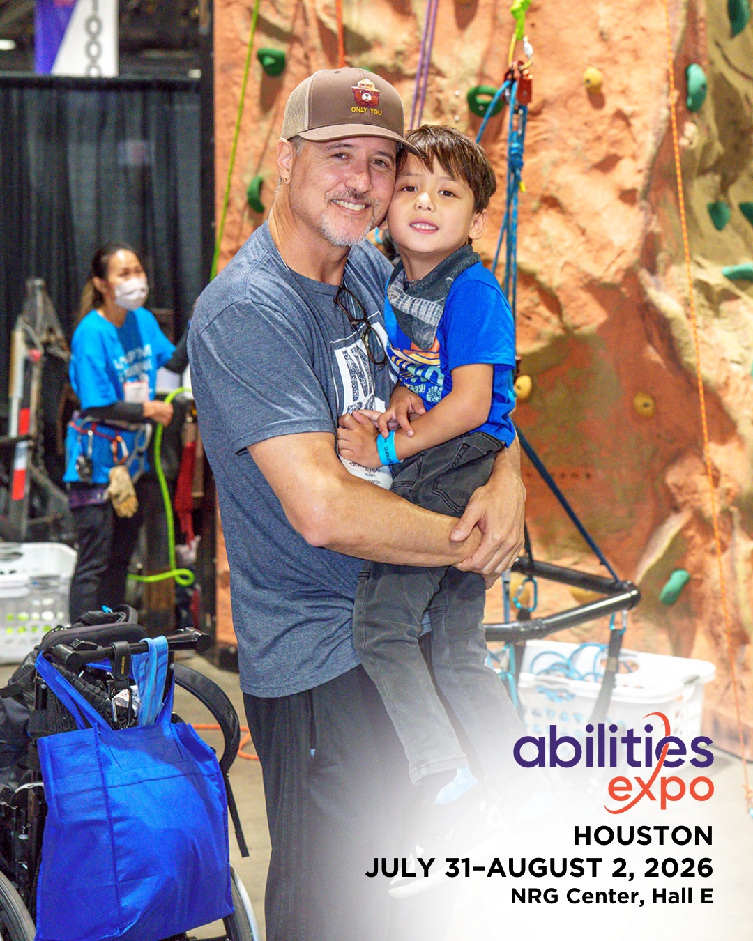 A father and young son pose in front of the adaptive climbing wall. The bottom corner reads 'abilities expo Houston, July 31-august 2, 2026, NRG Center, Hall E'