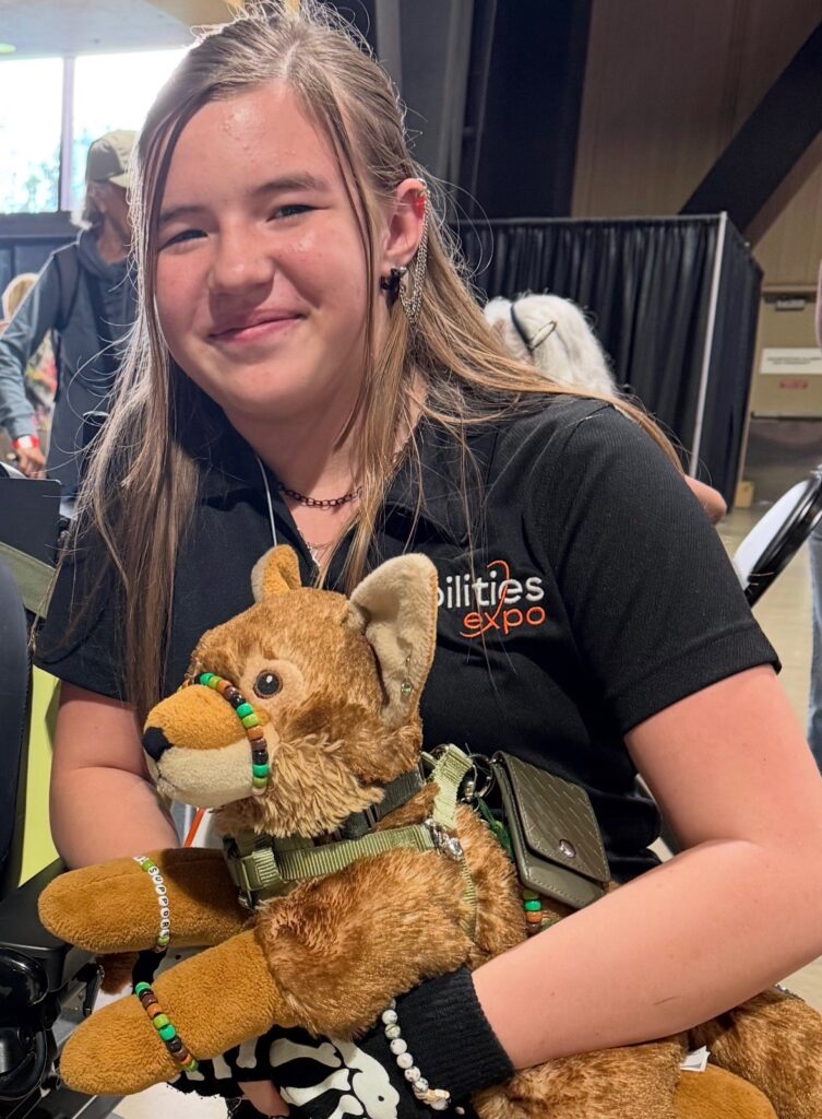 Kamryn Rhoades with her ESSA(Emotional Support Stuffed Animal) smiling for a picture