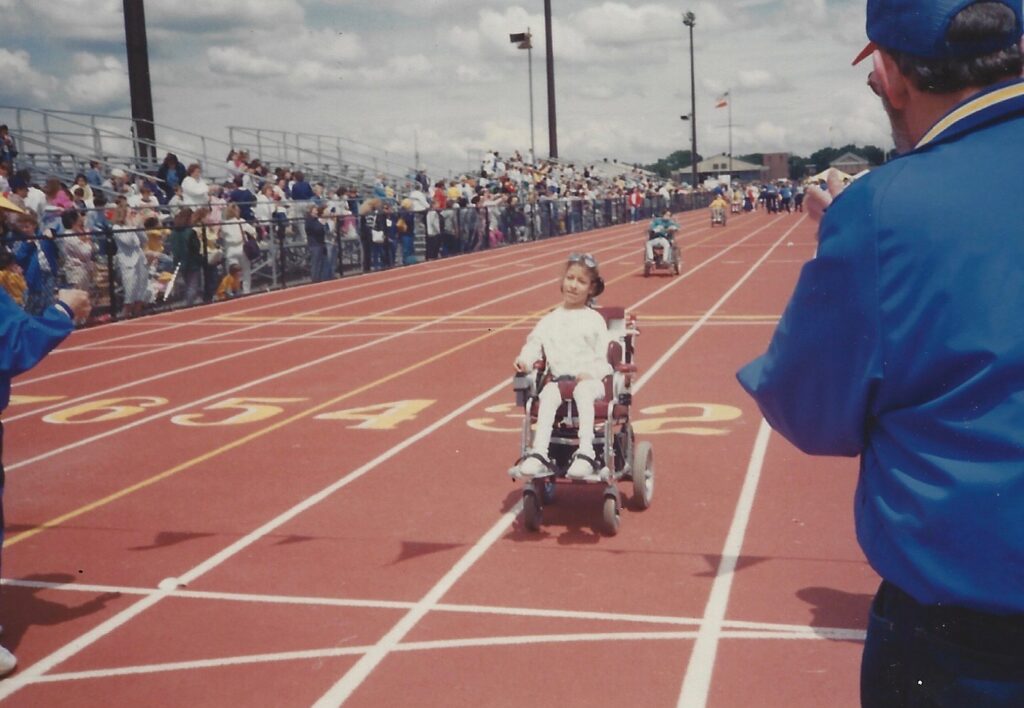 A photo of Yolanda Vicente as a young girl in a wheelchair race on a track