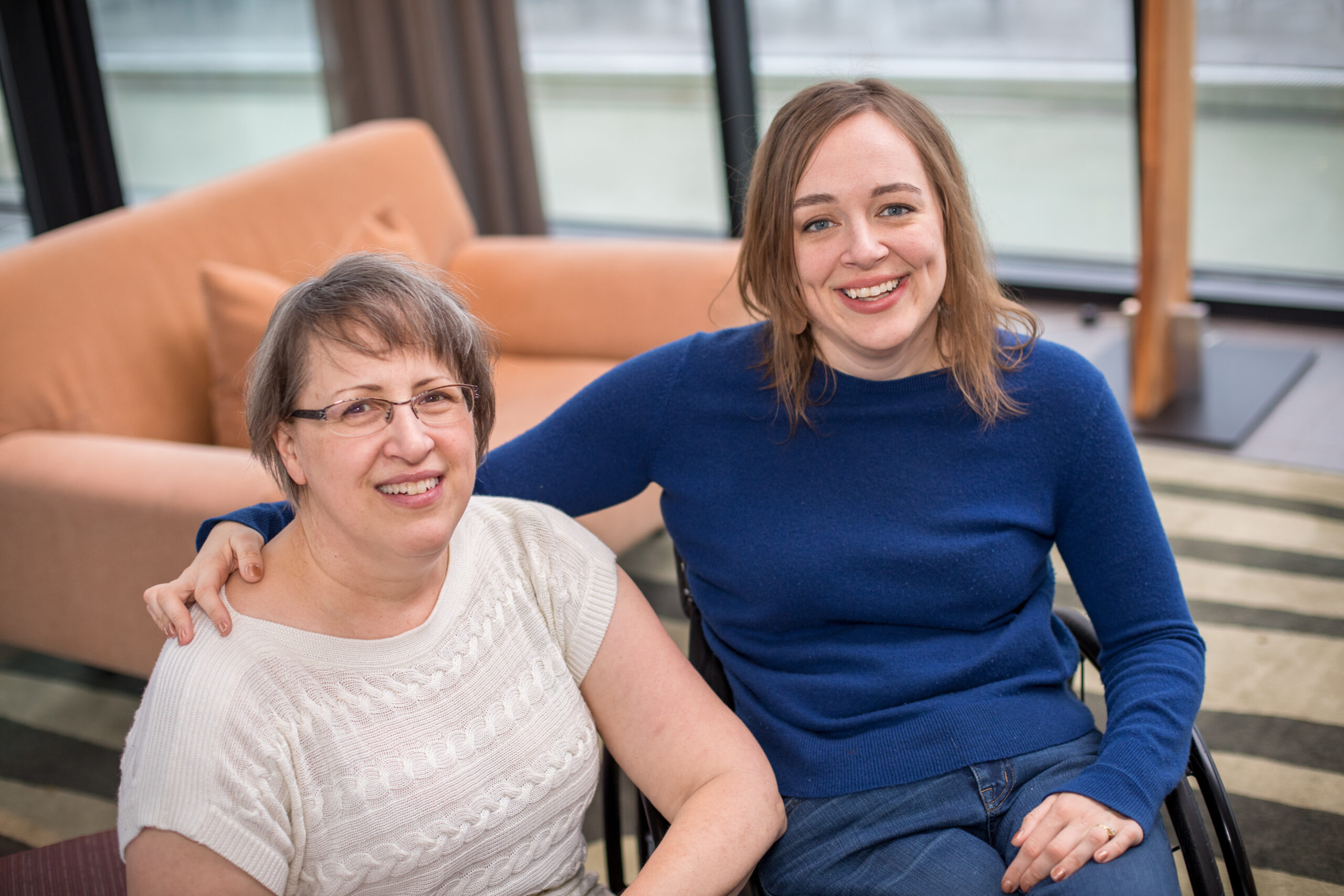 Cindy Kolbe and her daughter, who is a wheelchair user, smile at the camera next to each other