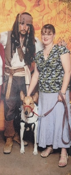 A woman and her service dog pose with Captain Jack Sparrow.