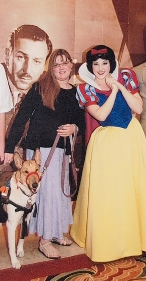A woman and her service dog pose with Snow White