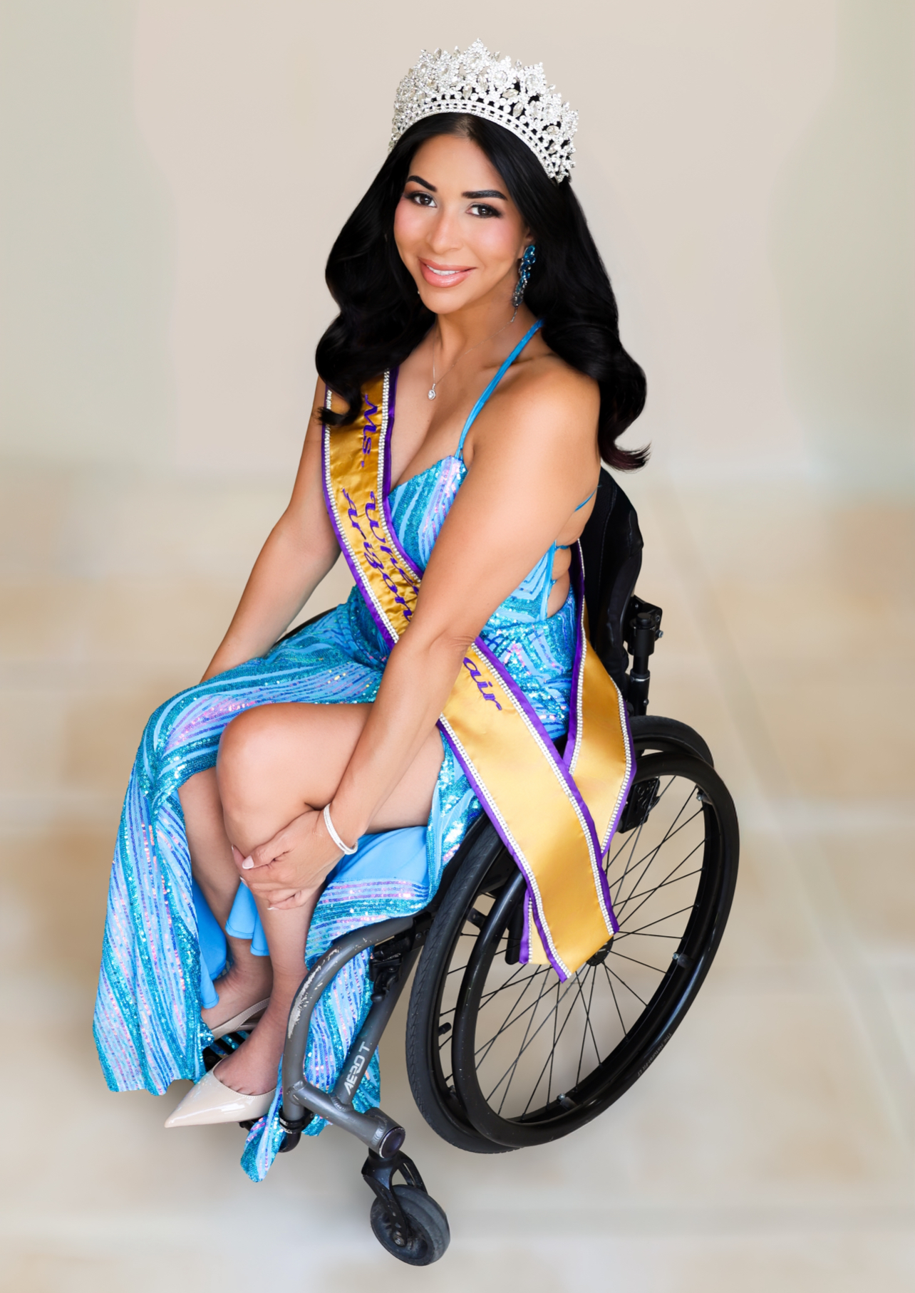 A photo of Carla Sanders, Ms. Wheelchair 2026 smiling in a blue gown and tiara